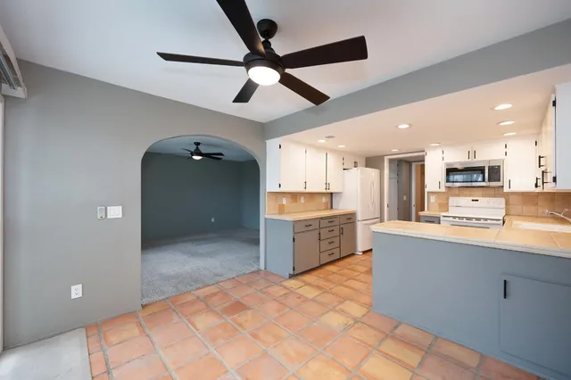 a large kitchen with stainless steel appliances kitchen island granite countertop a refrigerator a stove a sink and dishwasher