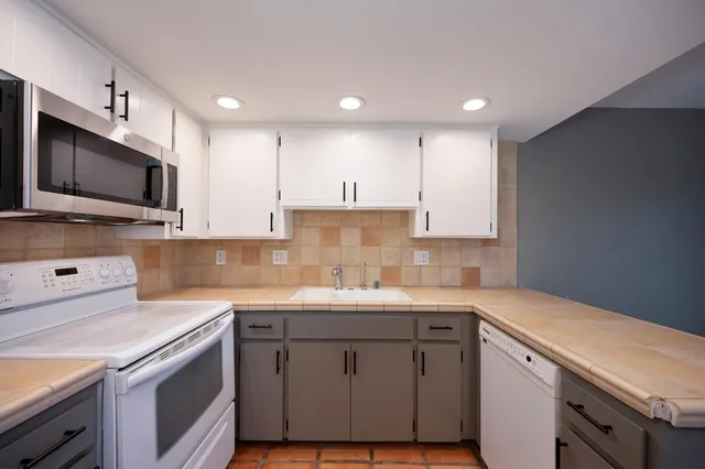 a kitchen with a sink a stove and cabinets