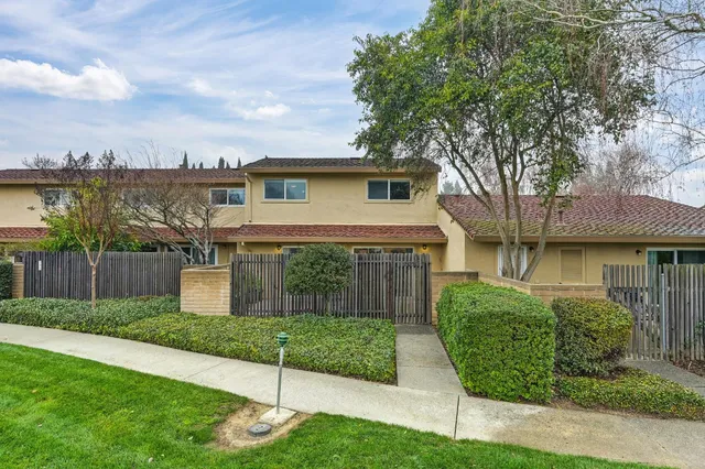 a view of a yard in front of a house with large trees