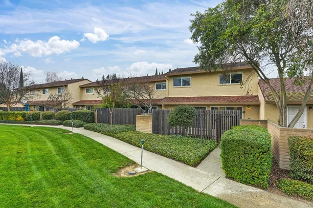 a view of a yard in front of a house with a fountain