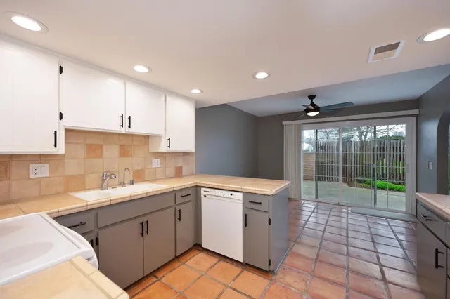 a kitchen with a sink a stove a refrigerator cabinets and a window