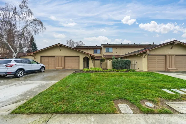 a front view of a house with a garden and garage