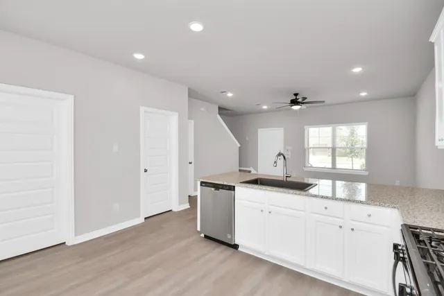 a kitchen with stainless steel appliances granite countertop a sink stove and wooden floor