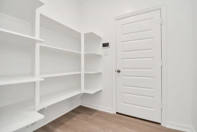 a view of walk in closet with empty racks