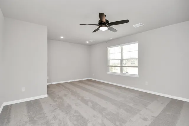 a view of empty room with ceiling fan