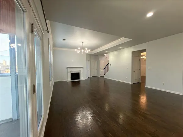 a view of empty room with wooden floor and fireplace