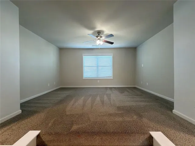 a view of a livingroom with a ceiling fan and window