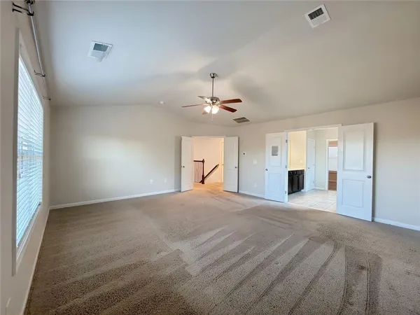 an empty room with a window and a ceiling fan