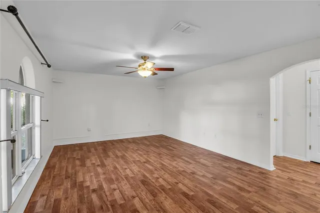 a view of an empty room with wooden floor and closet