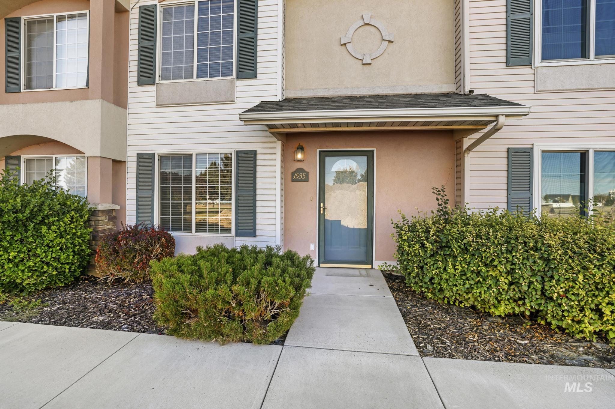 Entrance to property with a shingled roof and stucco siding