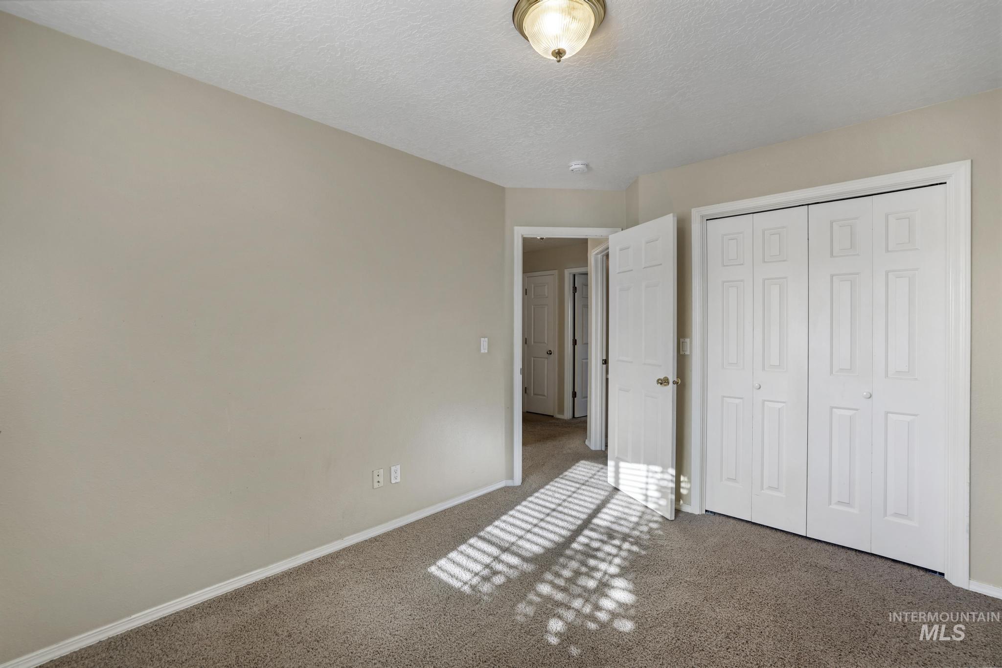 1935 Hampton Way Twin Falls, ID 83301 - Photo 22 of 25 Unfurnished bedroom featuring carpet, a textured ceiling, and a closet
