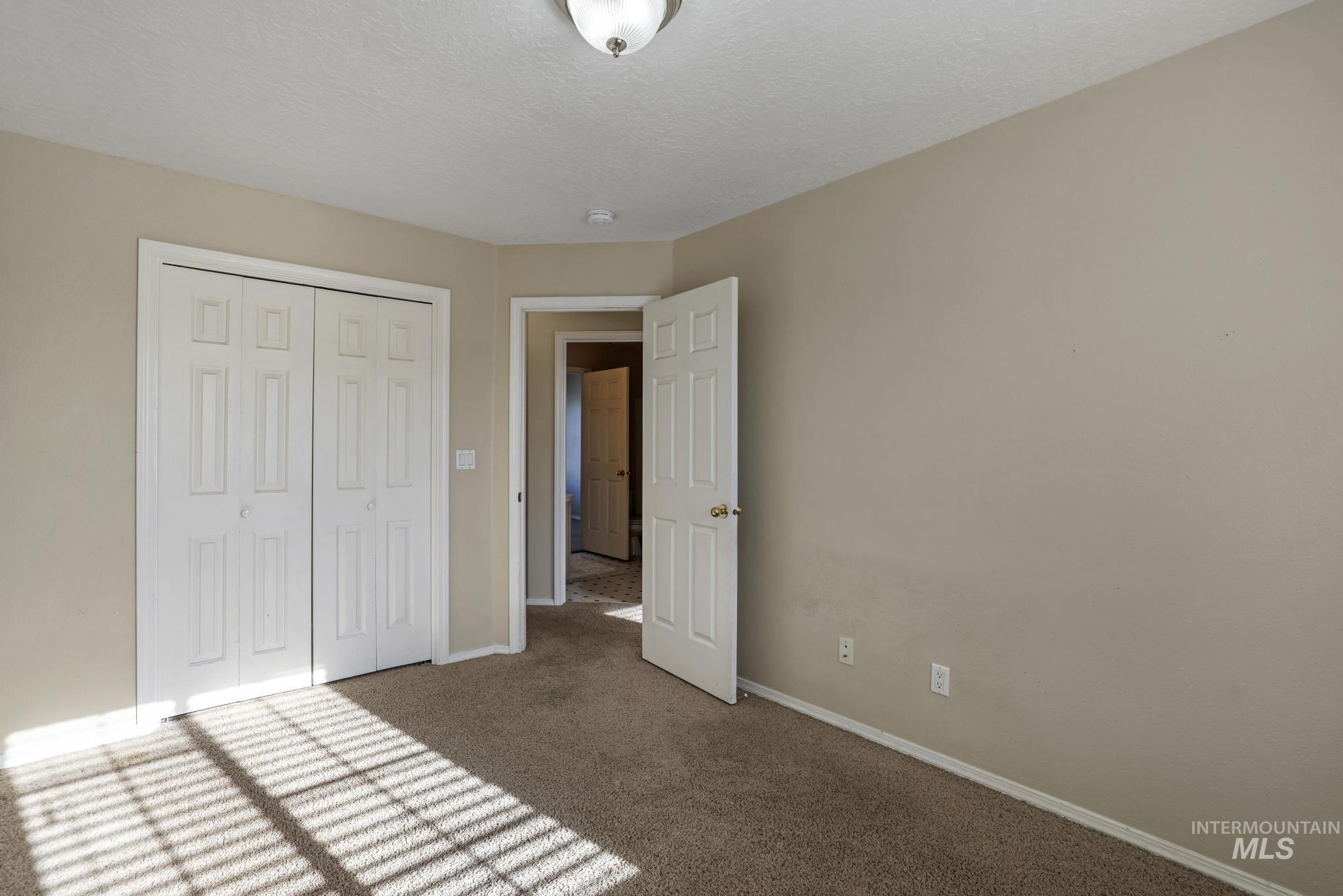 1935 Hampton Way Twin Falls, ID 83301 - Photo 23 of 25 Unfurnished bedroom featuring carpet flooring, a closet, and a textured ceiling