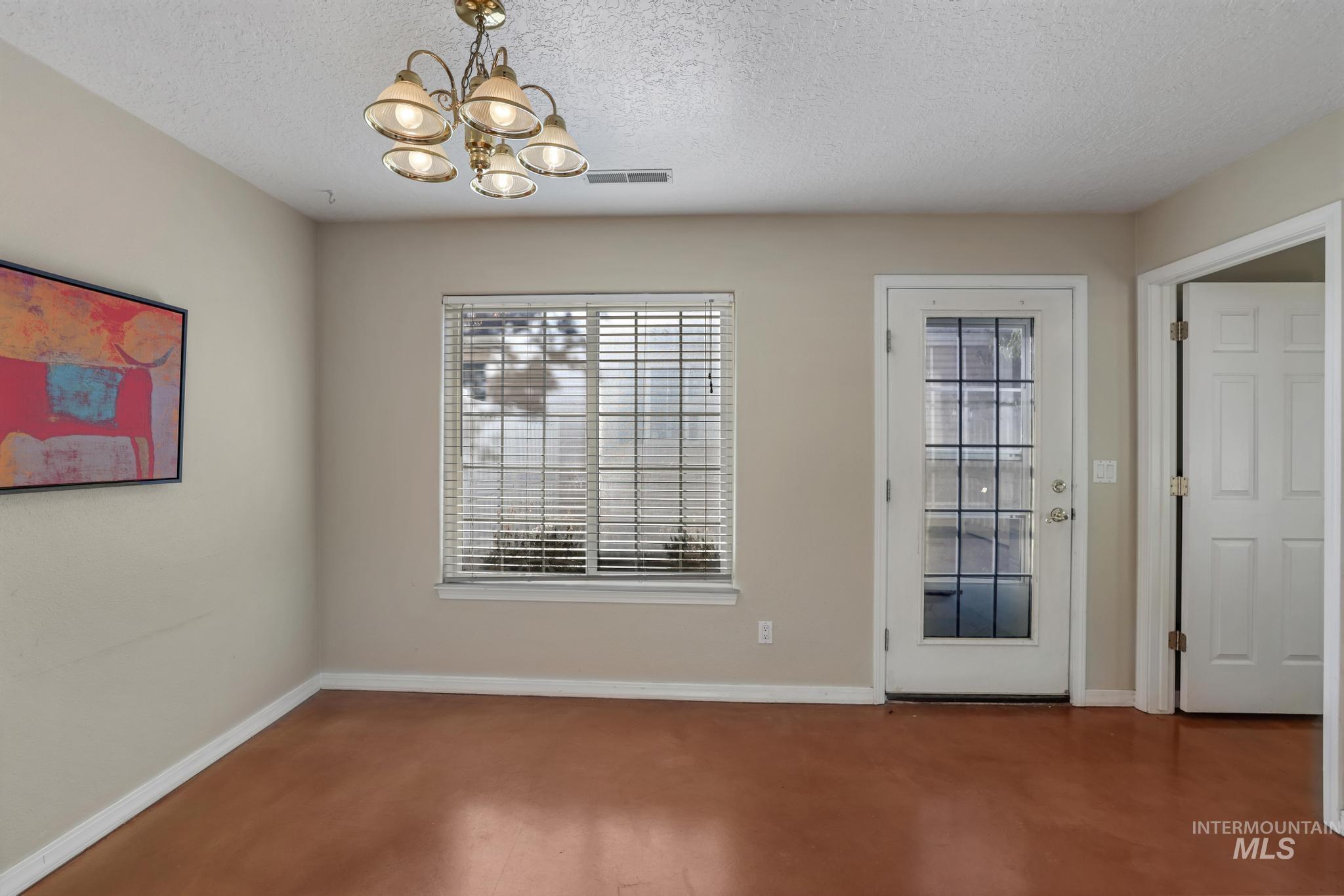 1935 Hampton Way Twin Falls, ID 83301 - Photo 8 of 25 Unfurnished dining area with a textured ceiling and a chandelier