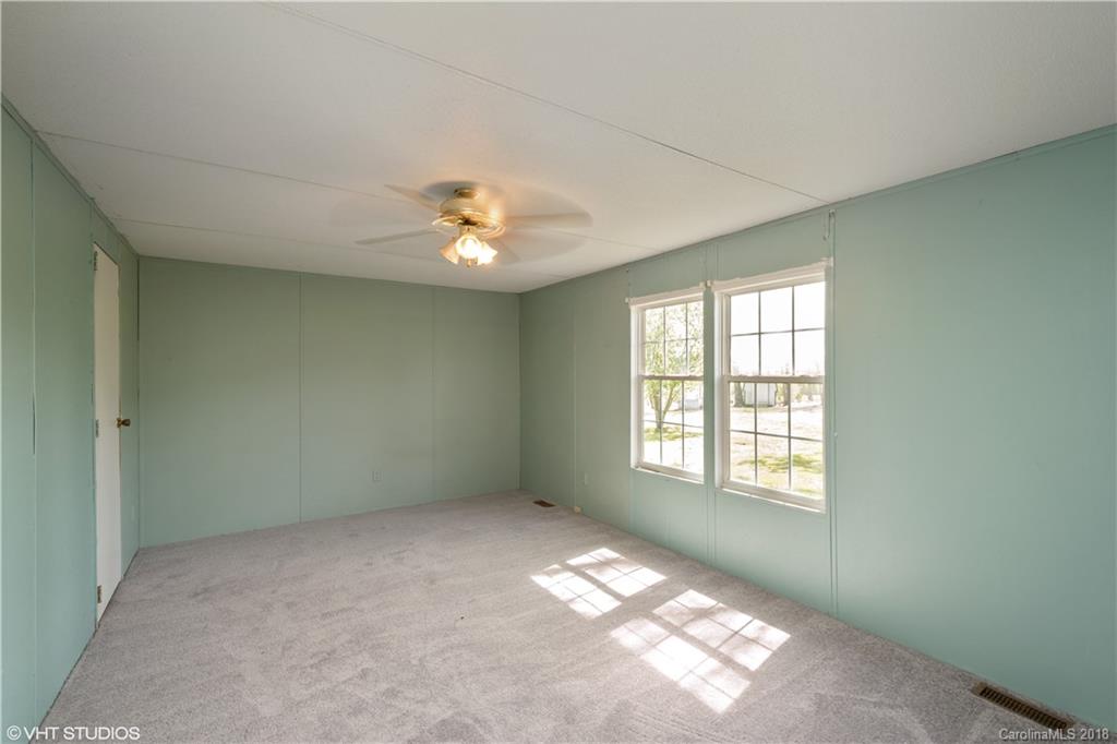 662 Lake Adger Road Mill Spring, NC 28756 - Photo 13 of 20 an empty room with windows and chandelier fan