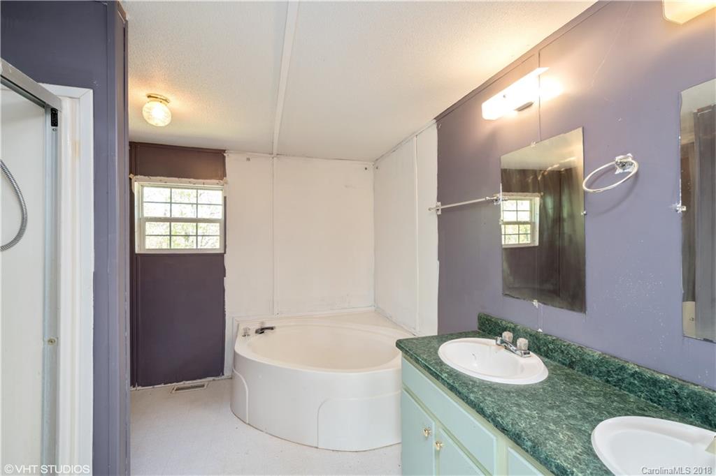 662 Lake Adger Road Mill Spring, NC 28756 - Photo 16 of 20 a bathroom with a granite countertop sink and a mirror