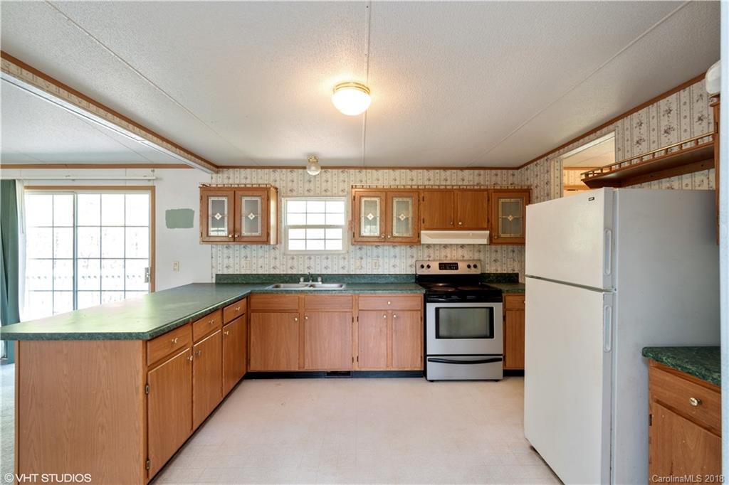 662 Lake Adger Road Mill Spring, NC 28756 - Photo 5 of 20 a kitchen with granite countertop stainless steel appliances a refrigerator sink and microwave