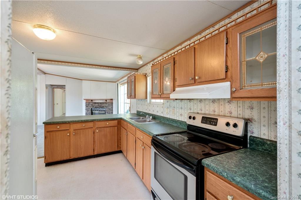662 Lake Adger Road Mill Spring, NC 28756 - Photo 6 of 20 a kitchen with granite countertop a sink and cabinets