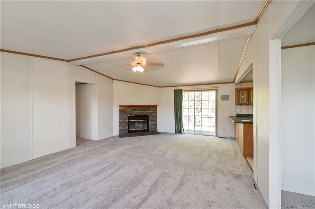 662 Lake Adger Road Mill Spring, NC 28756 - Photo 9 of 20 a view of empty room with a fireplace and a window