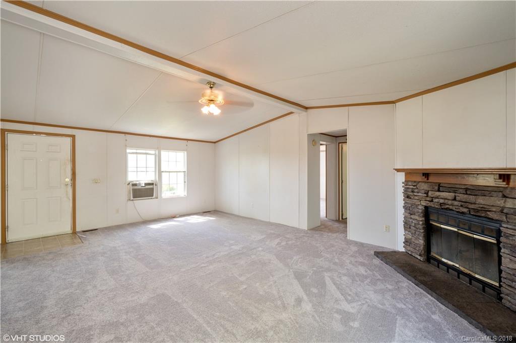 662 Lake Adger Road Mill Spring, NC 28756 - Photo 10 of 20 a view of empty room with a fireplace and windows