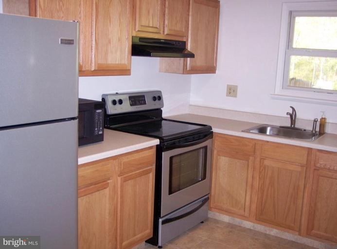 815 Corktree Road, Unit 815 Middle River, MD 21220 - Photo 5 of 13 a kitchen with granite countertop cabinets stainless steel appliances and a sink