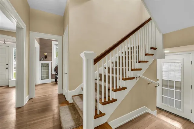 a view of staircase with lots of frames on wall and wooden floor