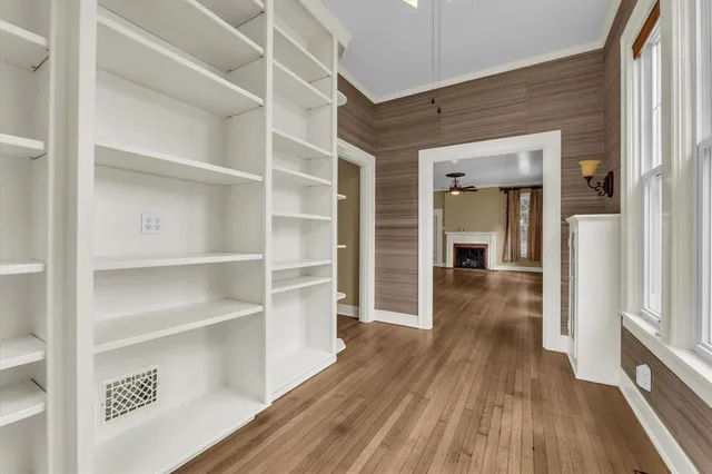 a view of a hallway with wooden floor and closet