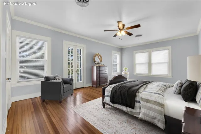 a spacious bedroom with a bed and wooden floor