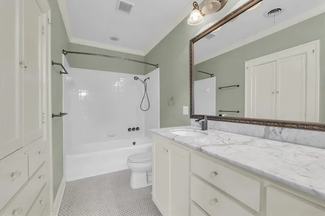 a bathroom with a granite countertop sink a toilet and a bathtub