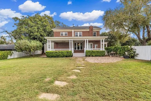 a front view of house with yard and trees around