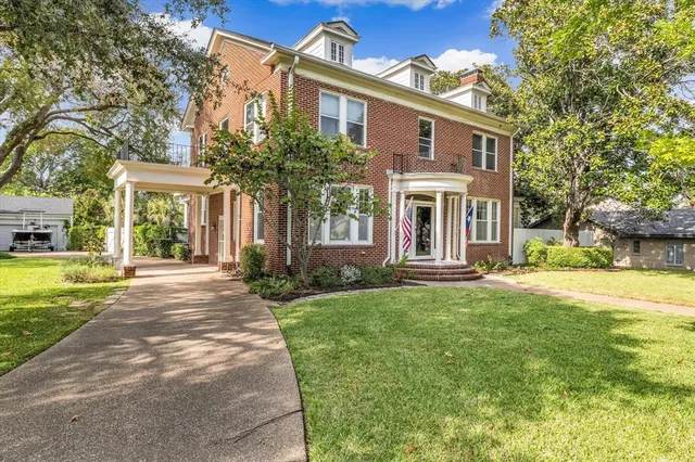 a front view of a house with yard and green space