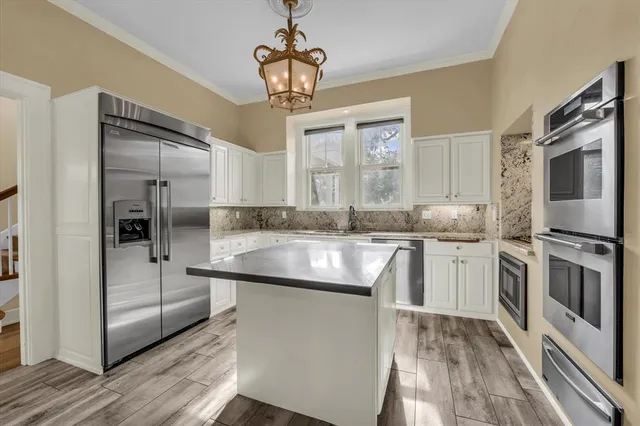 a kitchen with kitchen island granite countertop a sink appliances cabinets and counter space