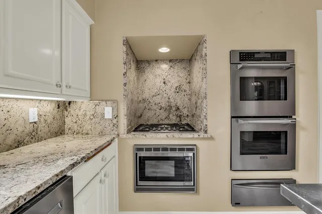 a kitchen with granite countertop a stove and a sink