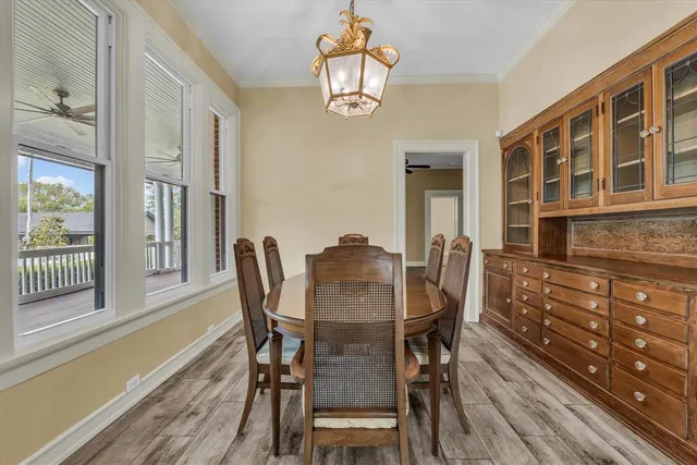 a dining room with furniture a chandelier and wooden floor