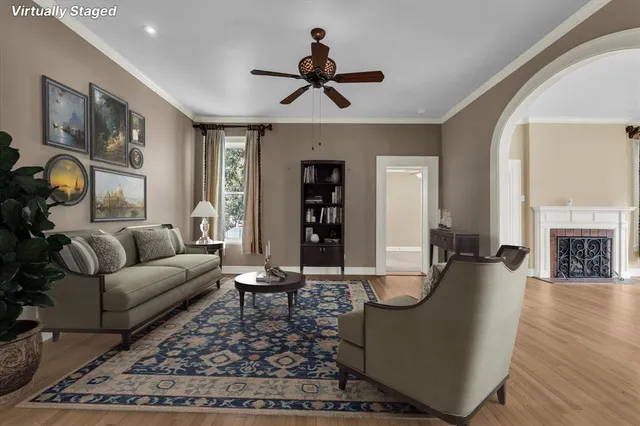 a living room with furniture a fireplace and wooden floor