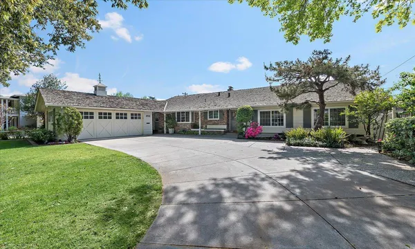 a view of house with a yard and potted plants