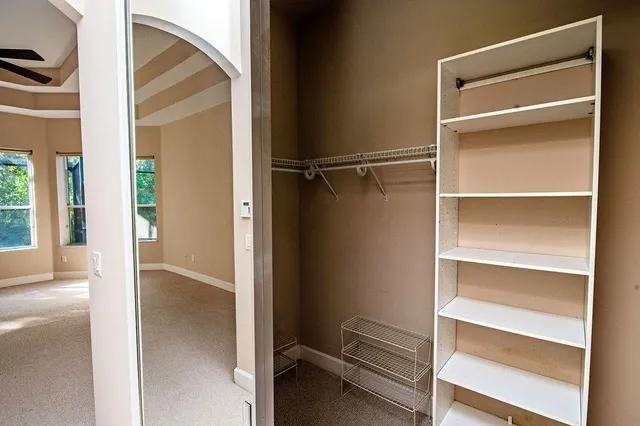 a view of an empty walk in closet and a window