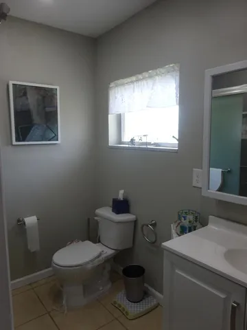 a bathroom with a toilet a sink and a window