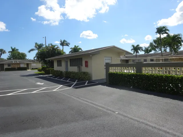 a view of a house with a yard and potted plants