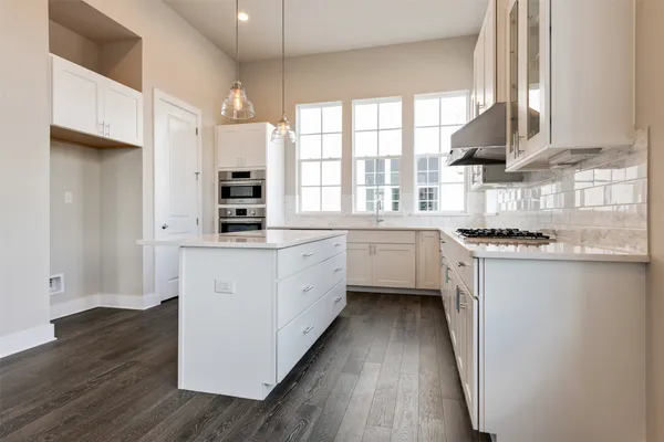 a kitchen with white cabinets and black stainless steel appliances