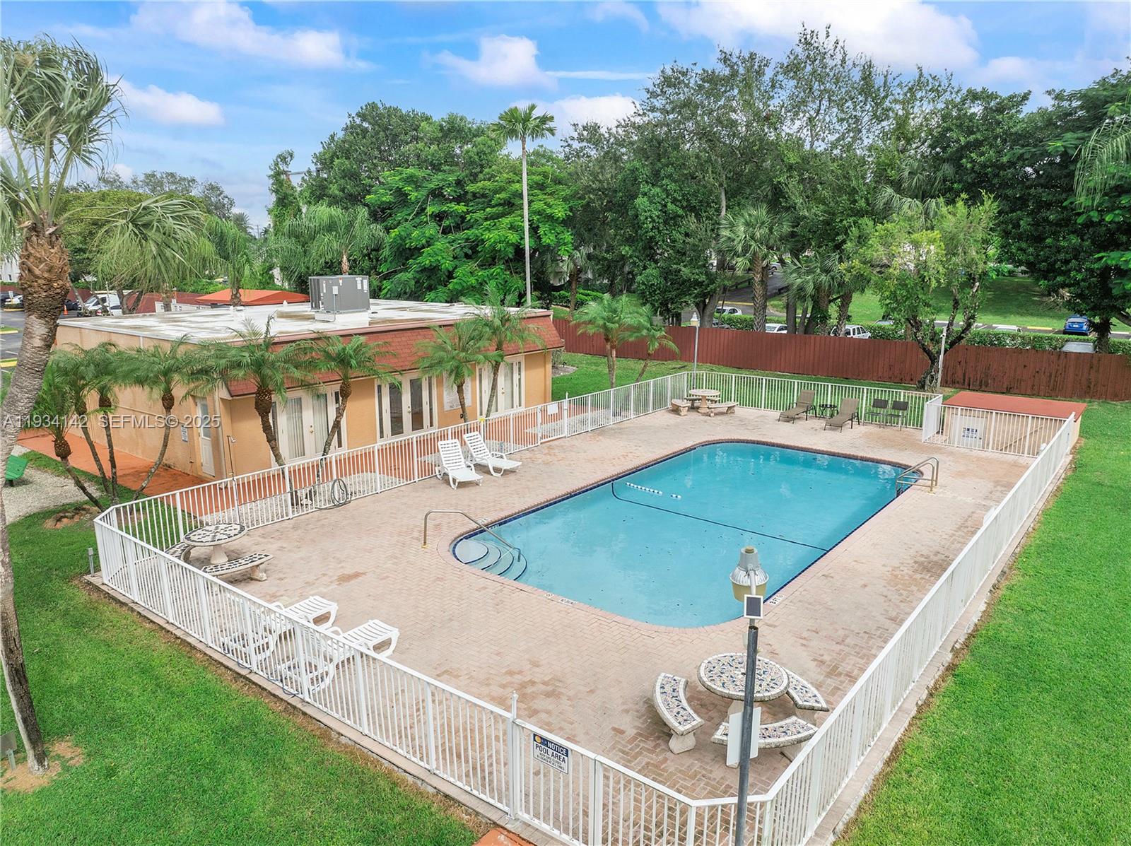 9974 Southwest 88th Street, Unit 1028 Miami, FL 33176 - Photo 17 of 24 a view of a swimming pool with a patio and a yard