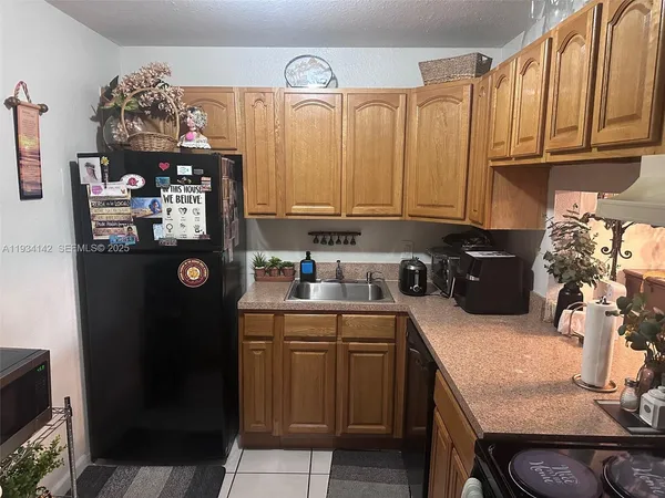 a kitchen with a sink refrigerator and cabinets