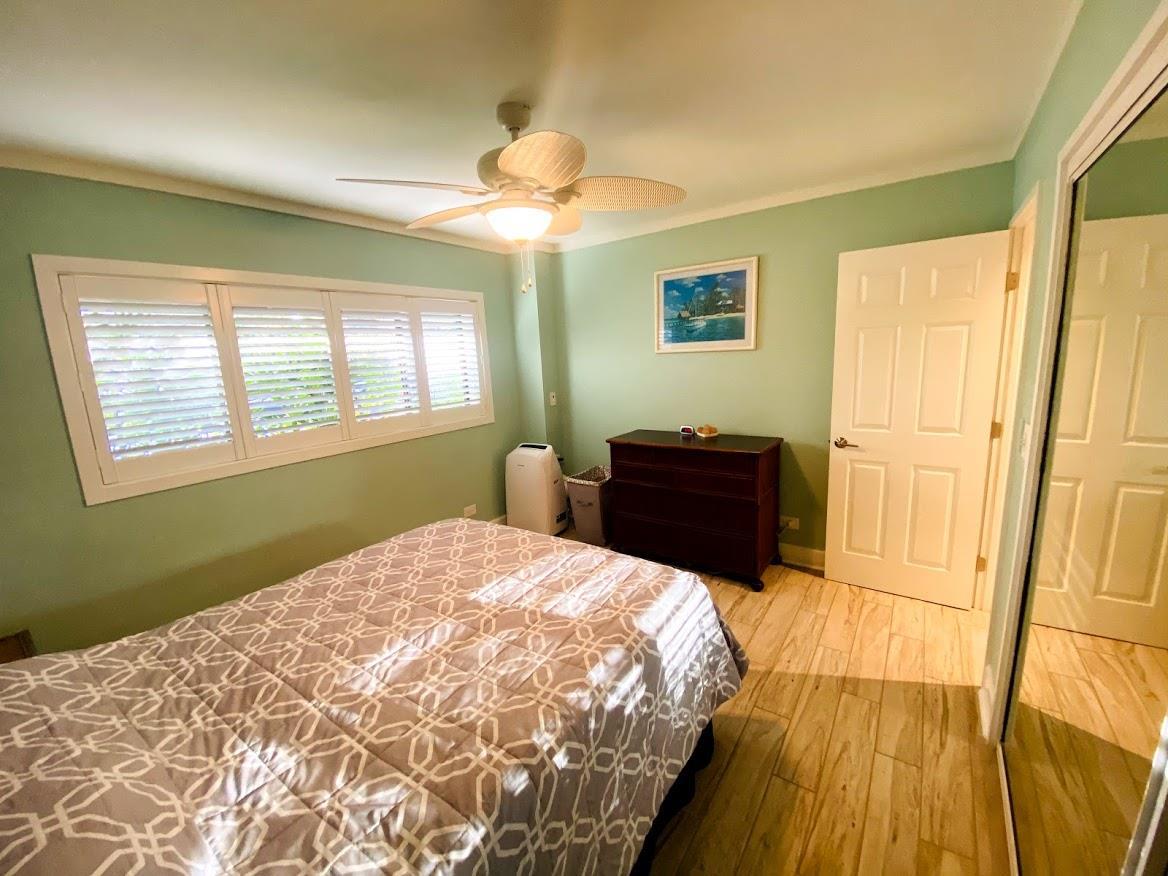3788 Lower Honoapiilani Road, Unit F103 Lahaina, HI 96761 - Photo 14 of 25 a bedroom with a bed and a dresser next to a window
