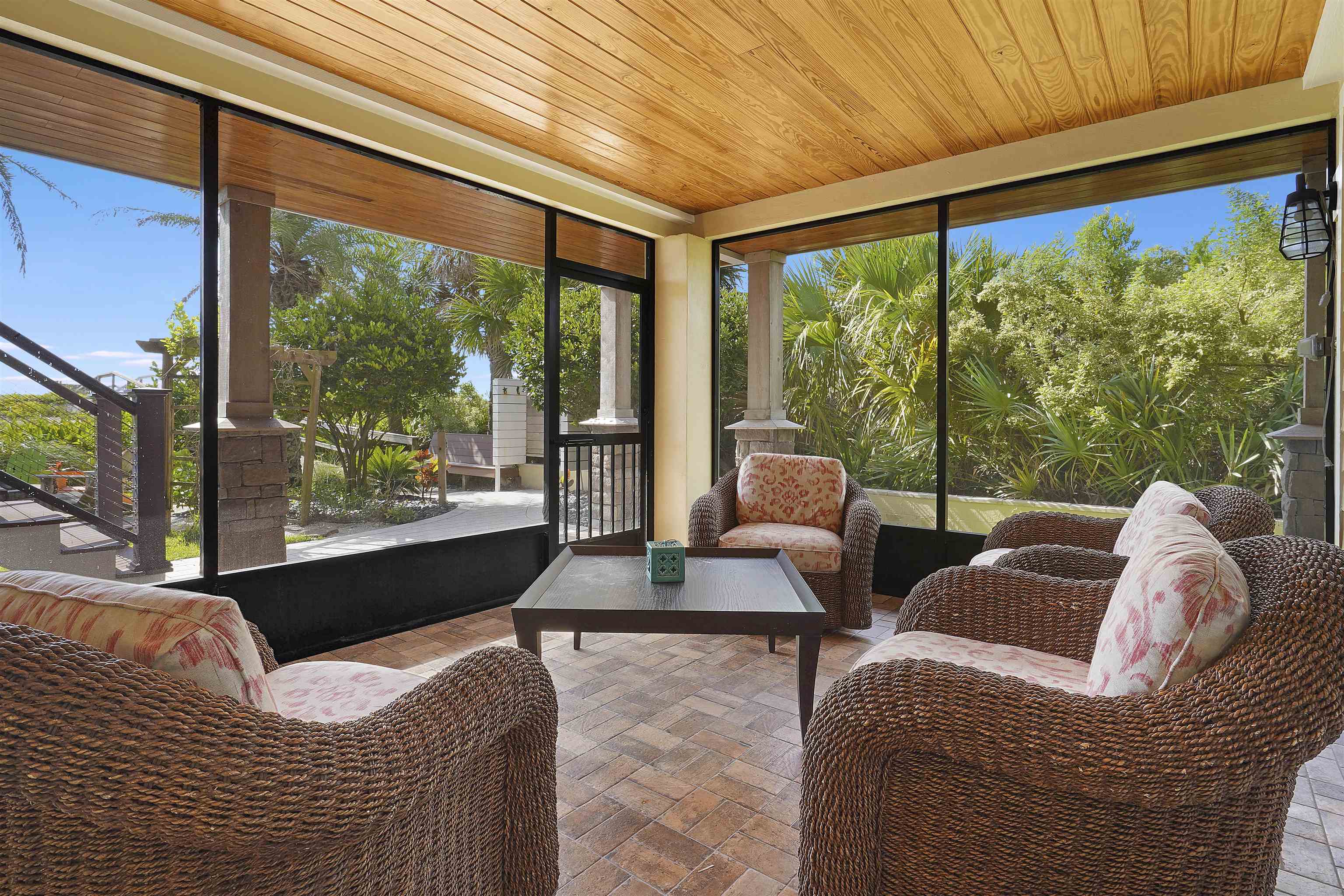 1 2nd Lane St. Augustine Beach, FL 32080 - Photo 18 of 81 a living room with couches floor to ceiling window and a flat screen tv