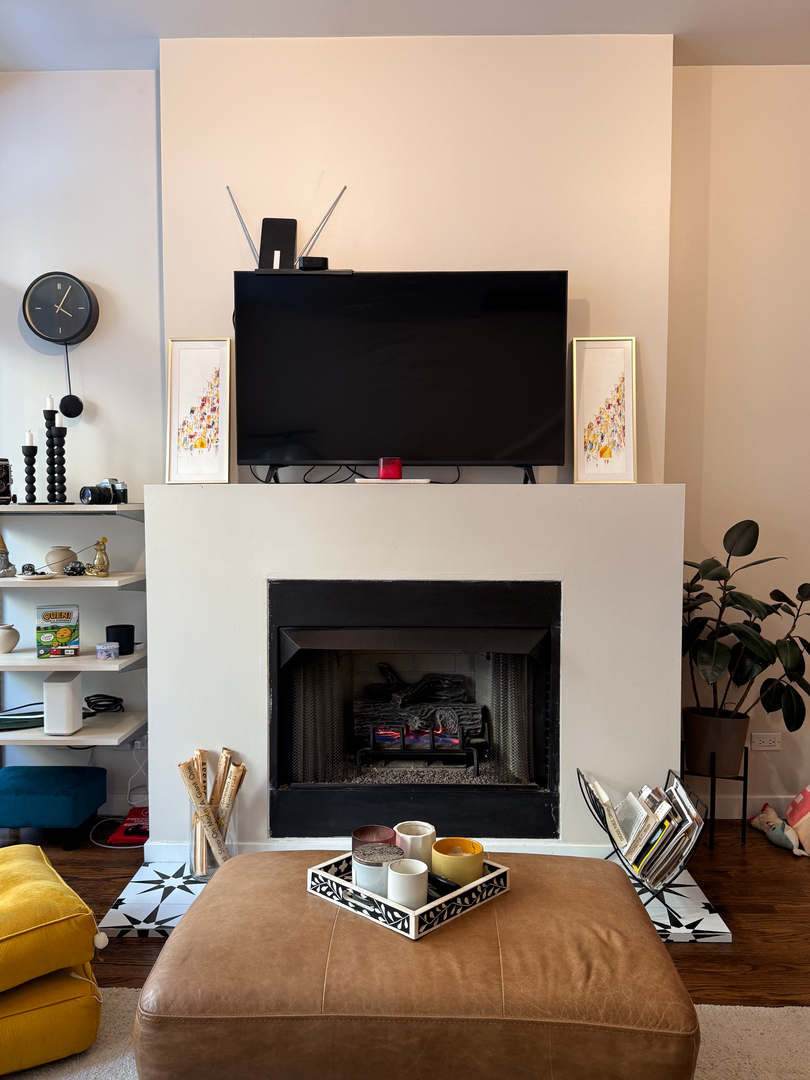 943 West Huron Street, Unit E Chicago, IL 60642 - Photo 16 of 22 a bedroom with a fireplace and a flat screen tv