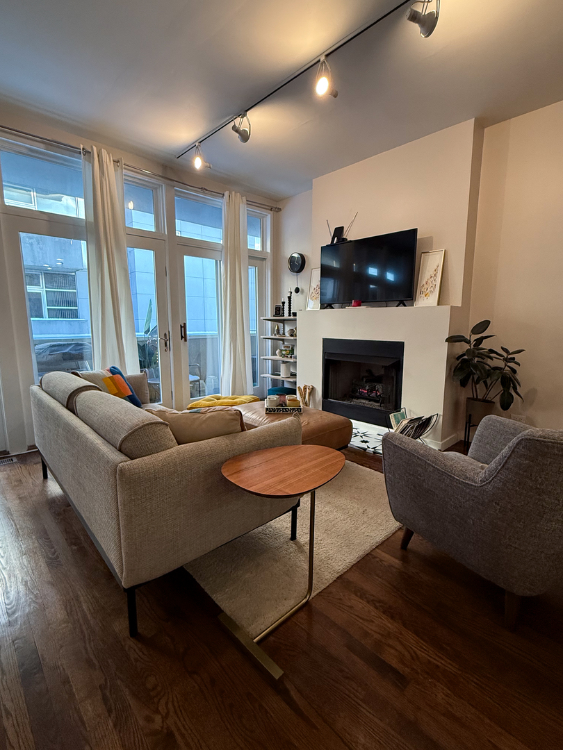 943 West Huron Street, Unit E Chicago, IL 60642 - Photo 6 of 22 a living room with furniture flat screen tv and a fireplace
