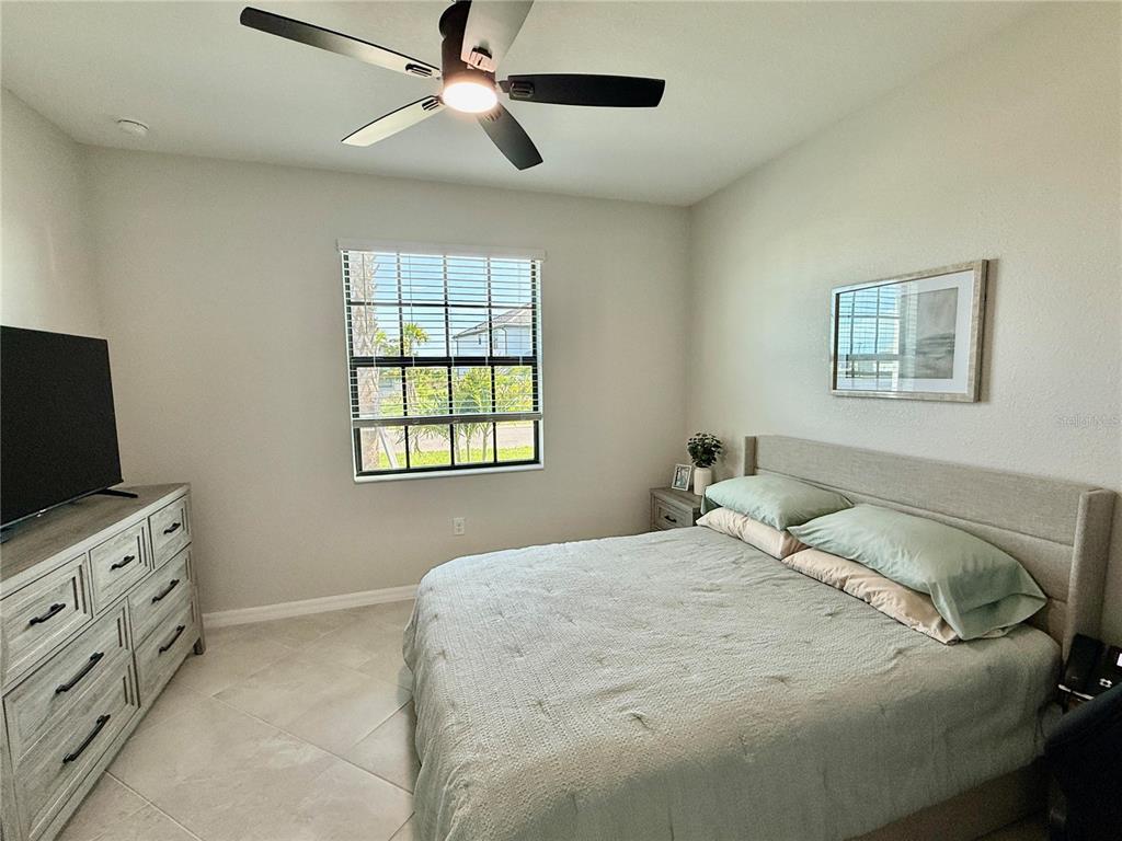 10852 Sun Drop Street Venice, FL 34293 - Photo 10 of 15 a bedroom with a bed and a flat screen tv