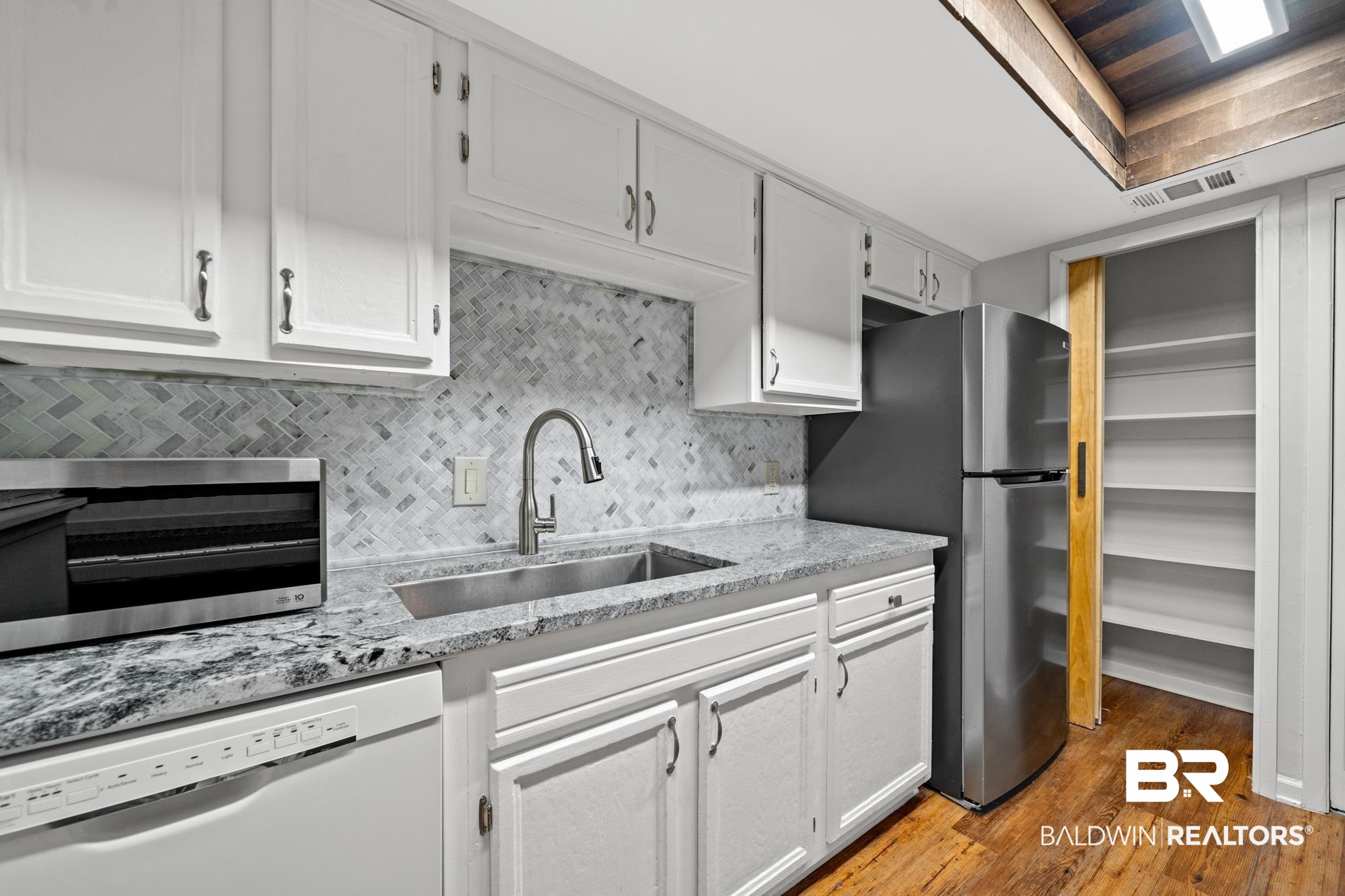 2901 Grant Street, Unit 802 Mobile, AL 36606 - Photo 15 of 37 Kitchen featuring white cabinets, white dishwasher, hardwood / wood-style flooring, stainless steel fridge, and sink