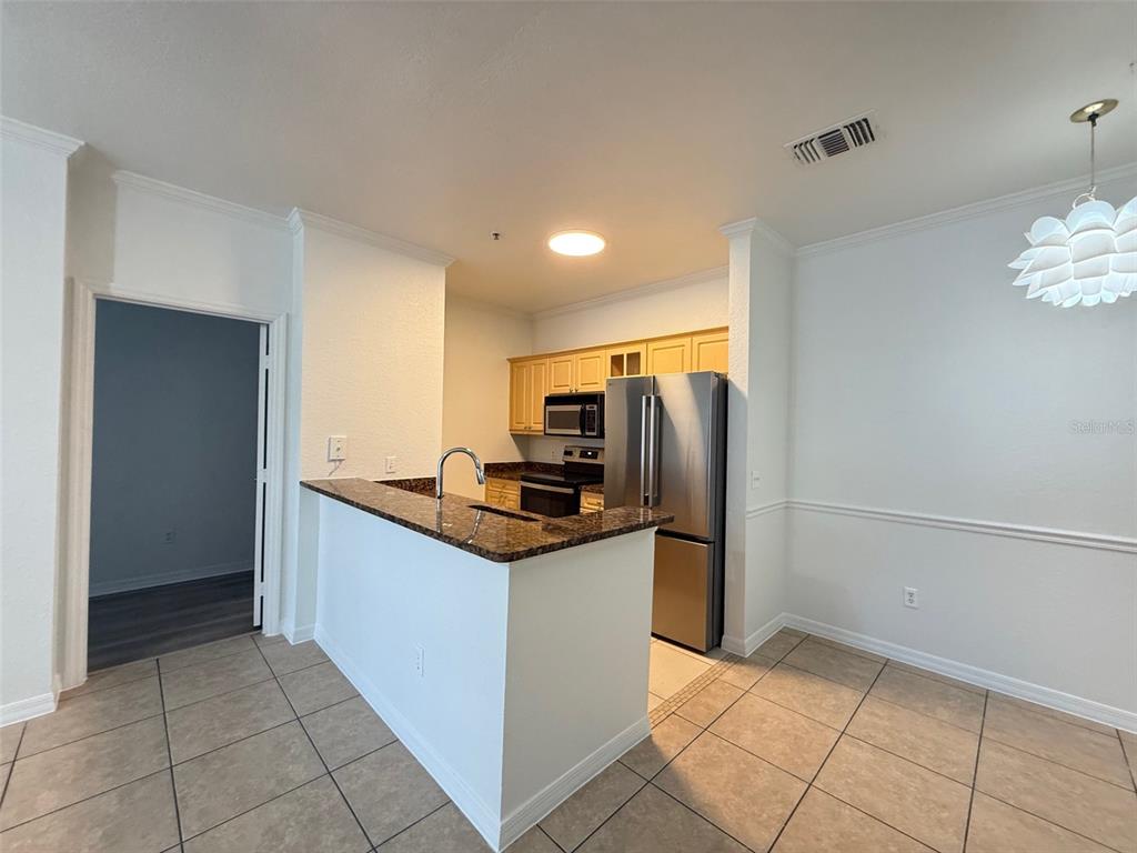 3611 Conroy Road, Unit 825 Orlando, FL 32839 - Photo 3 of 27 a kitchen with granite countertop a refrigerator and a sink