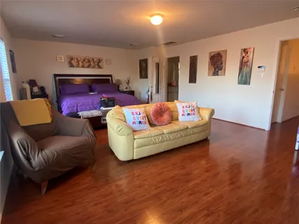 a living room with furniture and dresser with wooden floor