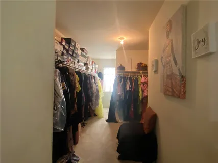 a view of walk in closet with clothes and shoes